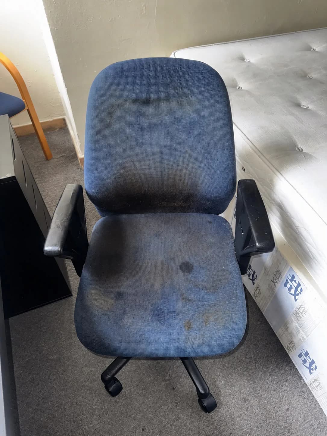 A marked blue office chair before professional cleaning